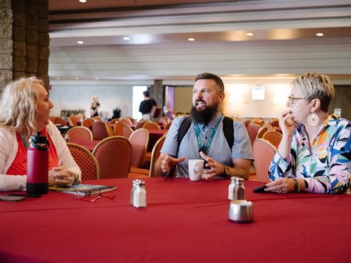 Three Arizona educators talk at a table the 19th Annual Teacher Leadership Institute, Tucson, June 2024.
