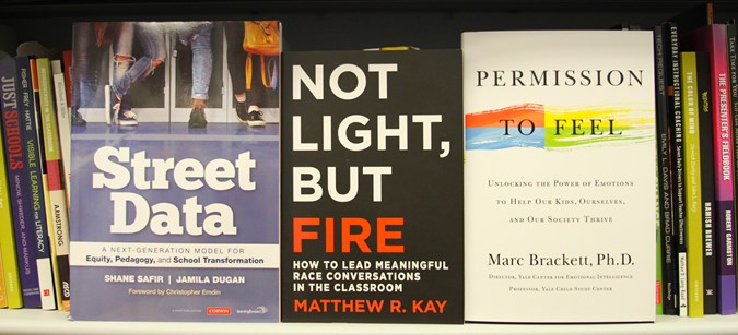 Three books are lined up facing out on a bookshelf: "Street Data" by Shane Safir and Jamila Dugan, "Not Light, But Fire" by Matthew R. Kay, and "Permission to Feel" by Marc Brackett